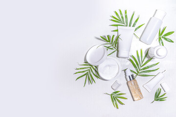 Beauty cosmetic skincare products on white background with tropical palm leaves flatlay copy space....