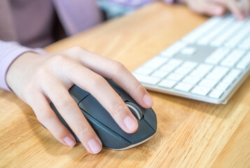 Girl's hand with computer mouse and keyboard