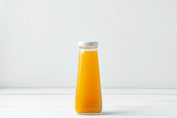 Small glass bottle of fresh juice on white background
