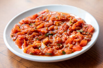 A spicy Turkish appetizer ezme made with tomatoes, bell pepper, parsley, mint, olive oil and hot chili.