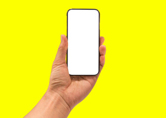 Fototapeta na wymiar Hand holding mobile smart phone, blank white screen on yellow background
