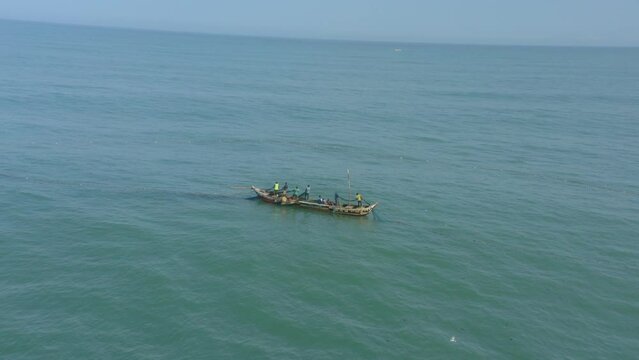 Fishermen at sea casting net in Ghana