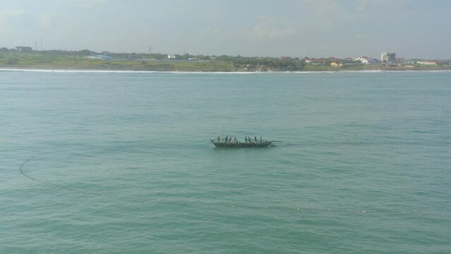 Fishermen at sea casting net in Ghana