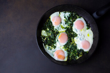 Eggs with spinach on a black background. Turkish name; ispanakli yumurta