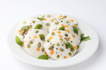 vegetable idli served with coriander and coconut chutney with tomato sauce