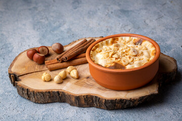 Baked rice pudding turkish milky dessert sutlac in earthenware casserole with hazelnuts