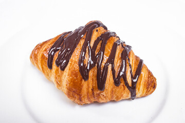 Fresh and tasty croissant  with chocolate  sauce over white background