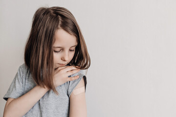 The girl was vaccinated in her arm, a plaster on her arm