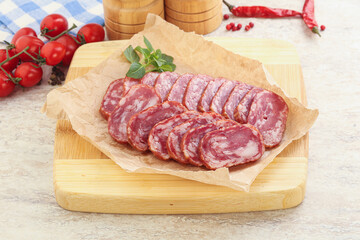 Sliced salami sausages over board