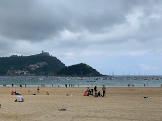 Obraz premium People enjoying summer day at San Sebastian beach La Concha in Basque Country