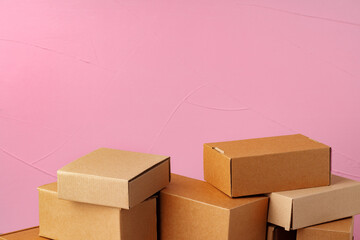 Set of cardboard boxes on pink background