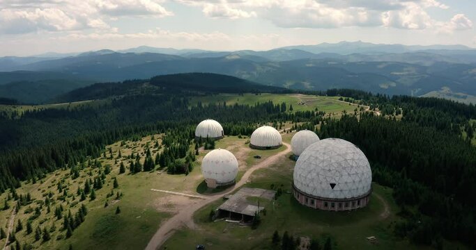 research observatory in the mountains on the Montenegrin ridge at the top of the Pamirs. white round structures in the mountains in the forest in a ray of sun. drone view