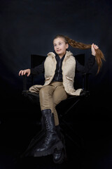 girl sitting on a chair holding her hair on a black background