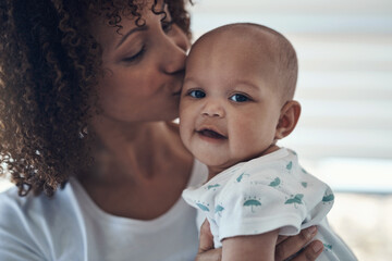 Grateful that life gave me the gift of you. Shot of a young woman kissing her adorable baby girl at home.