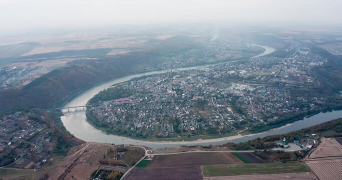 drone view of the town of Zalishchyky in the Ternopil region in Ukraine. the river snakes around the city, the bridge. overall plan. zoom forward camera