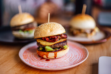 Close up of a big smokey burger with grilled cheese, has a special sauce.
