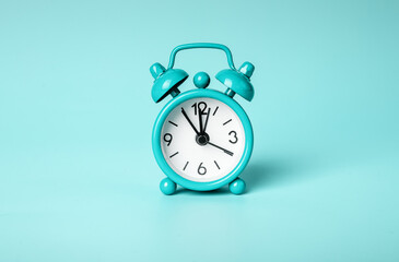 Retro vintage mint alarm clock on blue background. Time concept. Midday, midnight. High quality photo