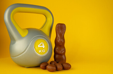 Kettlebell weight and chocolate Easter bunny. Healthy fitness lifestyle composition, gym workout...