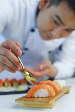 Japanese chef making traditional Japanese sushi at restaurant.