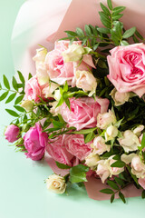 Mother's day, womens day or birthday card. Beautiful bouquet of blooming delicate pink roses on a green background.