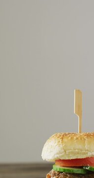 Vertical video of fresh homemade hamburger with salad on wooden background
