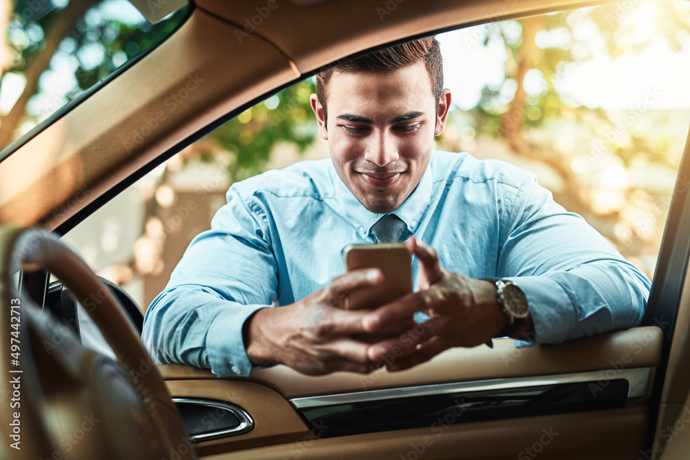 Poster staying close to his network even when on the go. shot of a young businessman using a cellphone whil