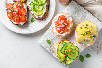 Sandwiches with feta, vegetables and fruits on a gray background. Top view, copy space.
