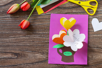 Greeting card Mother's Day with bouquet flowers tulips with the inscription of Mom. Children's art project, craft for children. Handmade. Craft for kids. Copy space.
