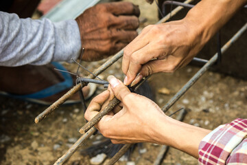 The mechanic is using a wire tied with steel.