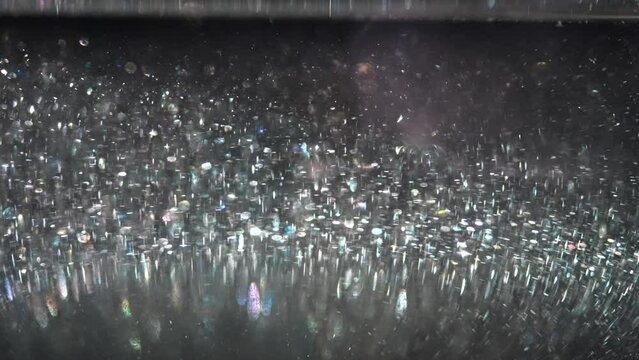 Close-up of a green liquid with sparkles shimmers in different colors in a container. Scientific background. Magic potion in a jar.