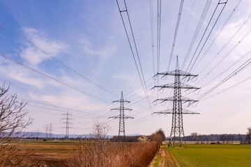 Aerial view with power lines of many electricity pylons in the countryside, Germany
