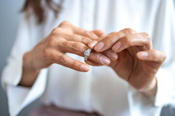 Unhappy woman holding wedding ring close up, upset girl crying, depressed with divorce, break up...