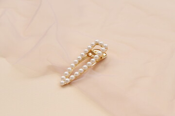 pattern of hair clips with pearls on beige background