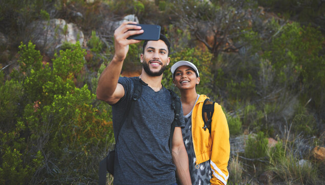 Making memories on our weekly hike. Shot of a young couple taking photos while out on a hike in a mountain range outside.