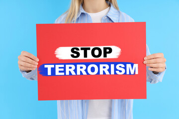 Woman holds banner with text Stop Terrorism