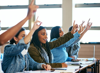 Theyve been paying attention. Cropped shot of a group of university students sitting with their hands raised in class.