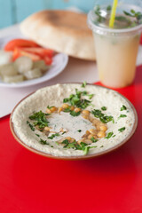 Hummus served with pita bread, vegetables and a cold beverage 