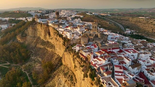 Camera rises over Arcos de la Frontera, Andalucia, Spain at sunset. Aerial shot one of famous pueblos blancos in Andalusia - Arcos de la Frontera