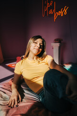Young attractive caucasian woman relaxing on a bed in sunlight.