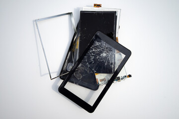 A broken electronic tablet on a white isolate. Repair of mobile equipment.Replacement of glasses on the phone.