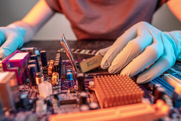 Engineer repairman holding hands CPU to insert into the socket of the motherboard. Technology...