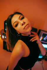 Portrait of young attractive caucasian woman in stylish outfit posing near stand with retro tvs.