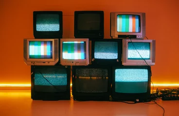 Fototapeten Alte Vintage-Fernseher auf einer Etage in einem Raum mit farbigem Neonlicht. © nikkimeel