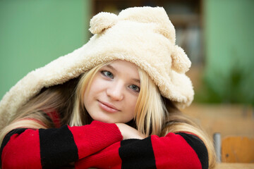 High school student. Sad blue-eyed teenage girl in a fur hat with ears.