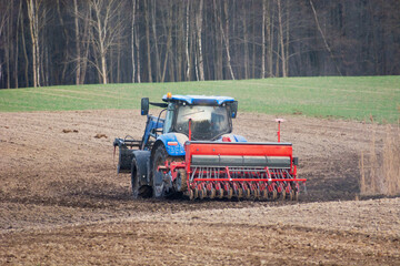 Obraz premium Tractor with a grain seeder in the field