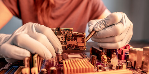 Engineer's gloved hand holds the chip board on the background of the motherboard. High-tech...