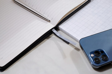 Fototapeta premium Communication technologies. On the table is a mobile phone, a diary, a pen.