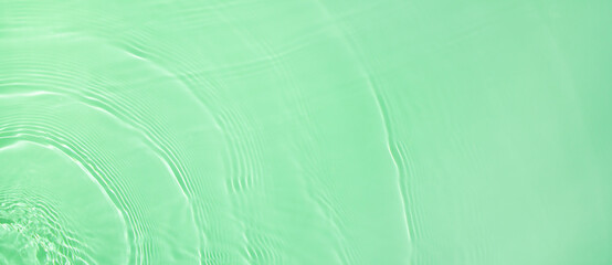 Abstract summer banner background Transparent green clear water surface texture with ripples and splashes. Water waves in sunlight with copy space Cosmetics moisturizer micellar toner emulsion