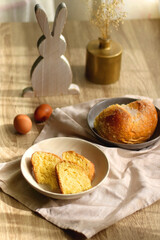 Plate of traditional sweet bread, eaten at Easter time in Croatia. Easter bunny, eggs and flowers on the table. Selective focus.