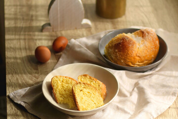 Plate of traditional sweet bread, eaten at Easter time in Croatia. Easter bunny, eggs and flowers on the table. Selective focus.